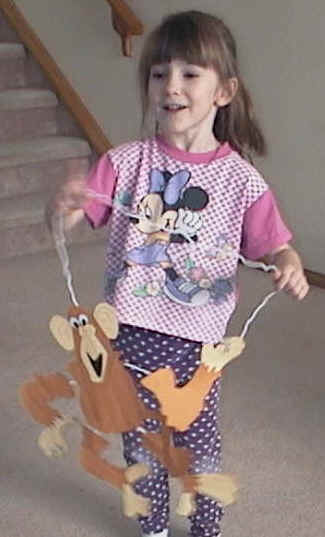 photo of a young girl playing with her finished monkey puppet craft