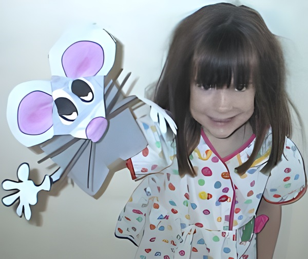 photo of a happy 6 year old girl with her hand made paper bag mouse puppet
